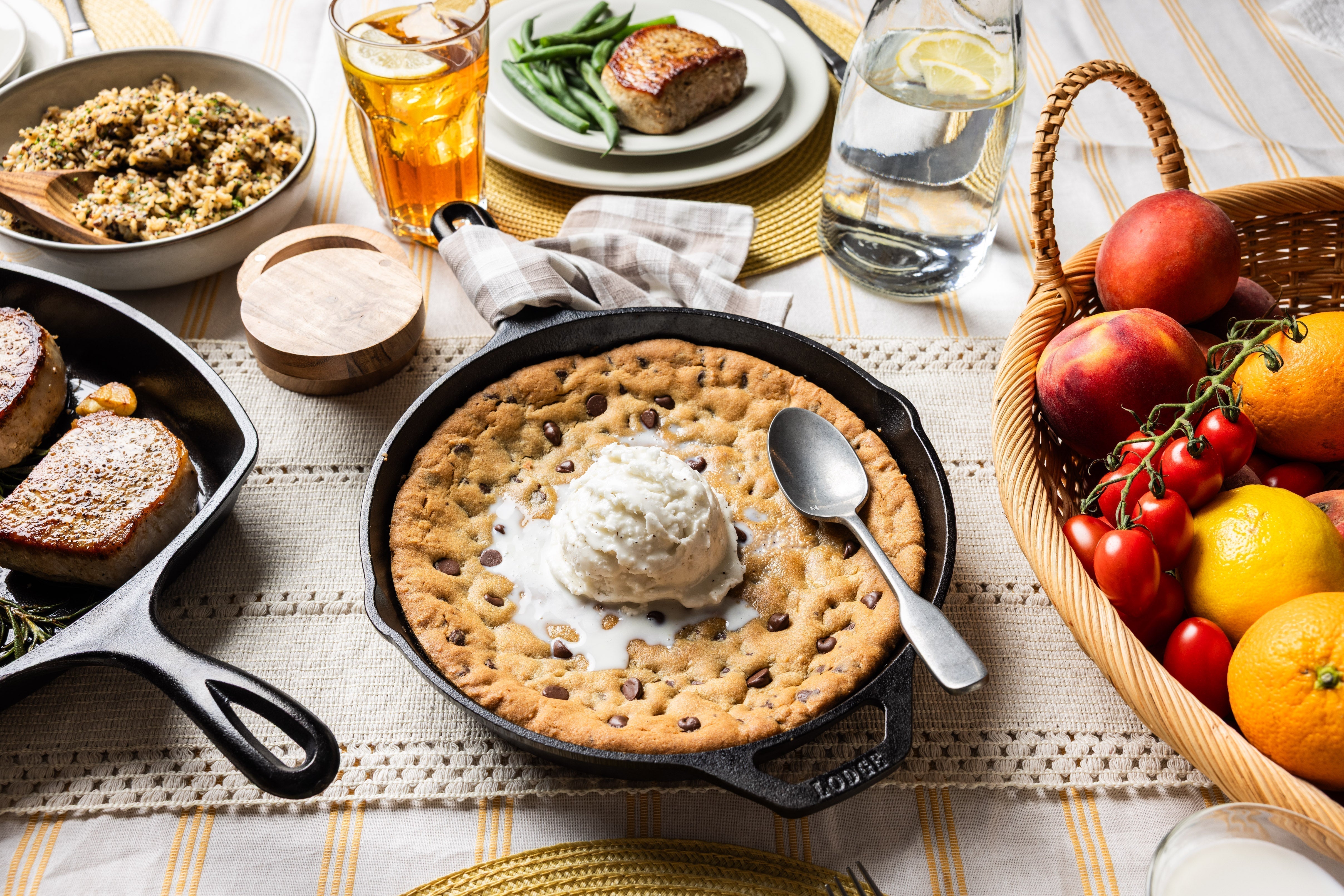 Cookie served in skillet on kitchen table topped with ice cream.