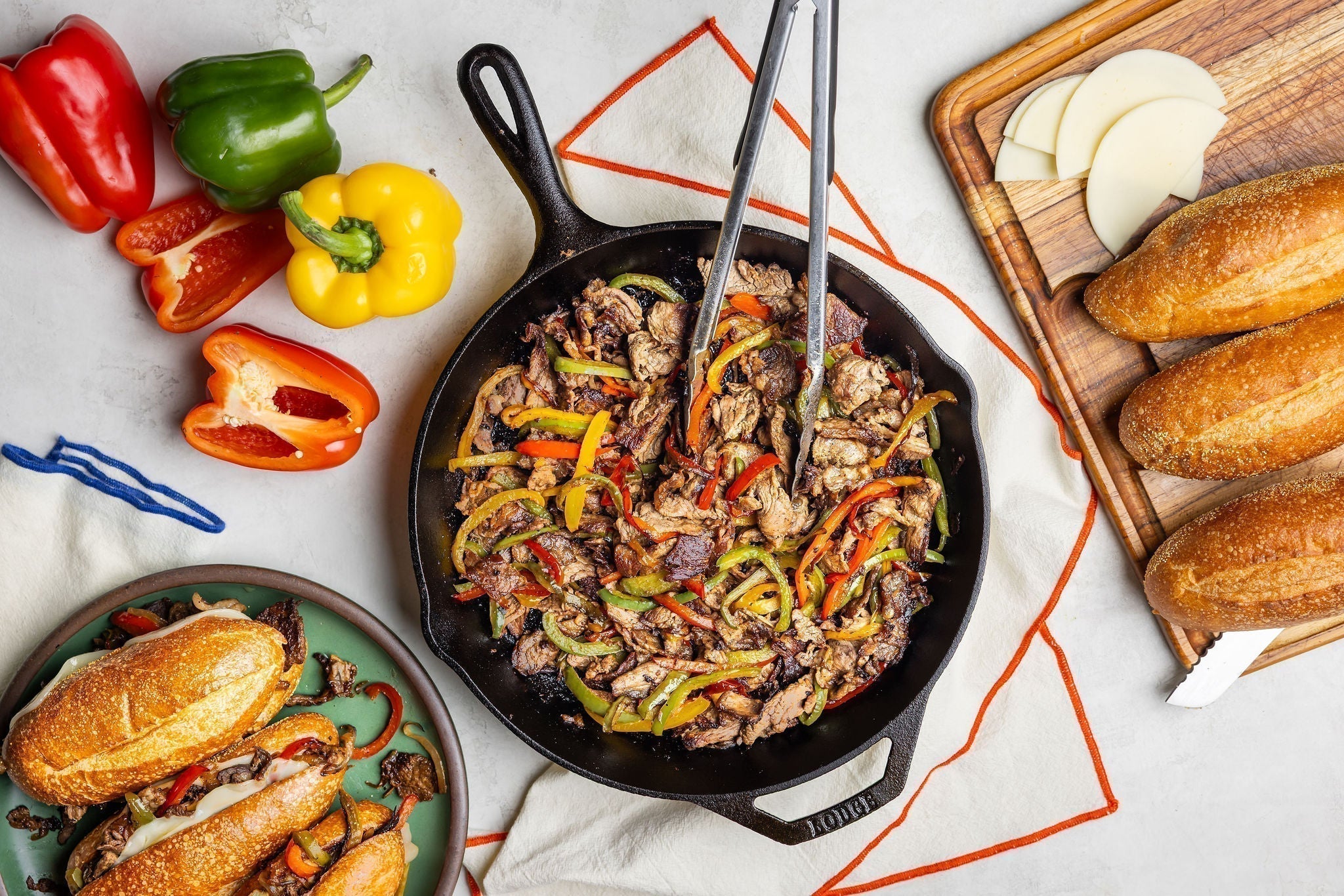 Philly Cheesesteaks served from skillet with fresh bread.