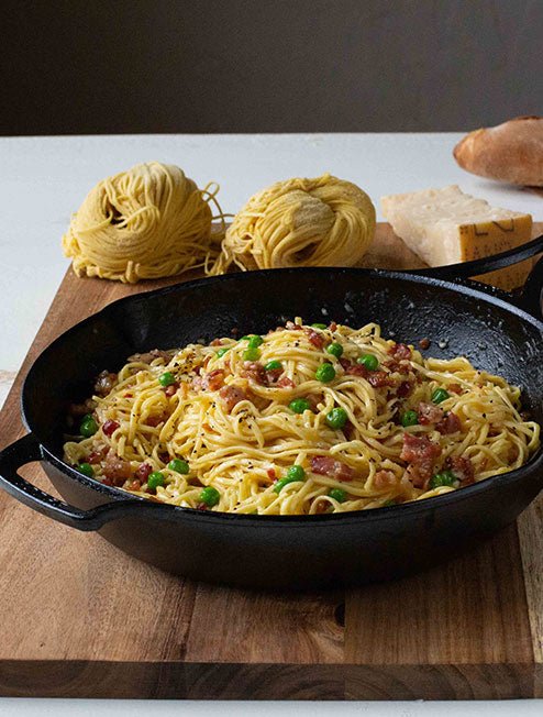 Fresh pasta Bolognese served in skillet on counter.