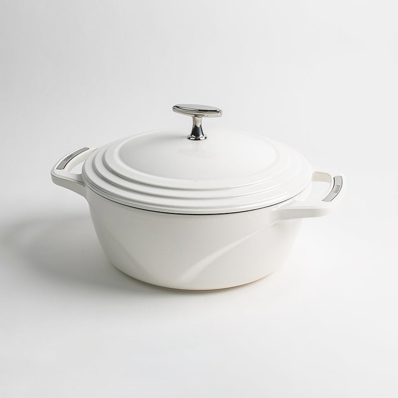 White enameled cast iron Dutch oven with a lid on a white background