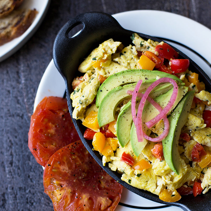 Fresh scrambled eggs served in product on top of plate.