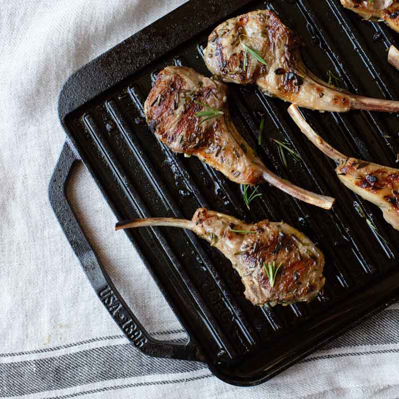 Herb-marinated lamb chops freshly prepared and presented on grill pan.