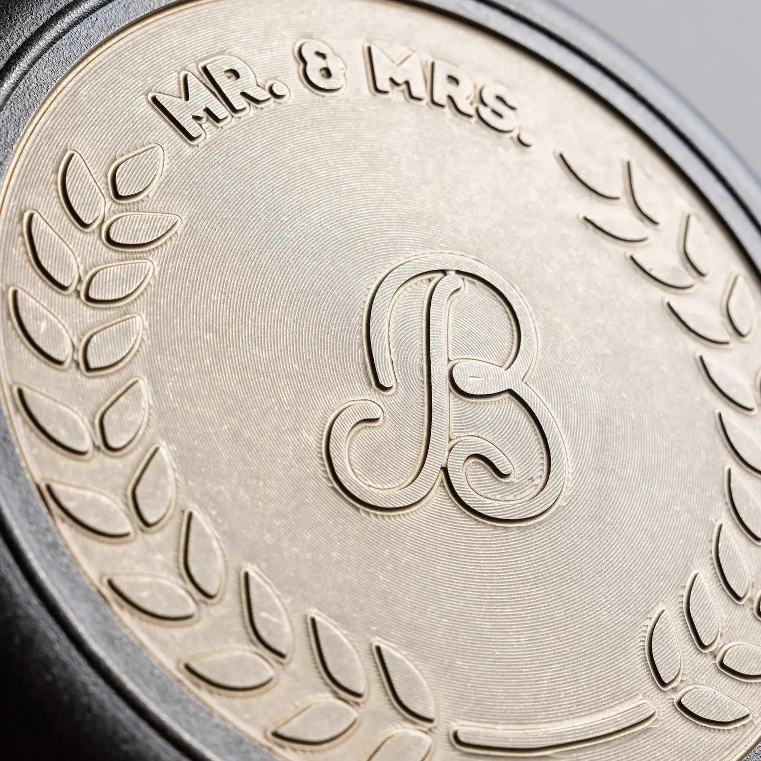 Close-up of bronze engraving on back of skillet, middle initial in cursive font.