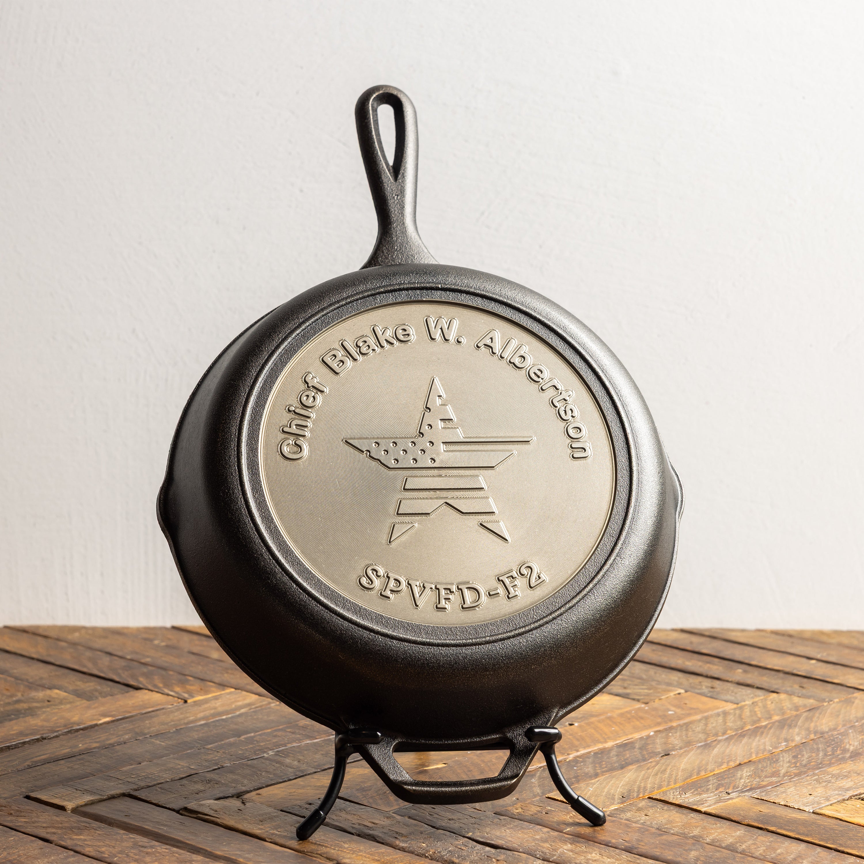 Personalized skillet displayed on a counter with a display stand.