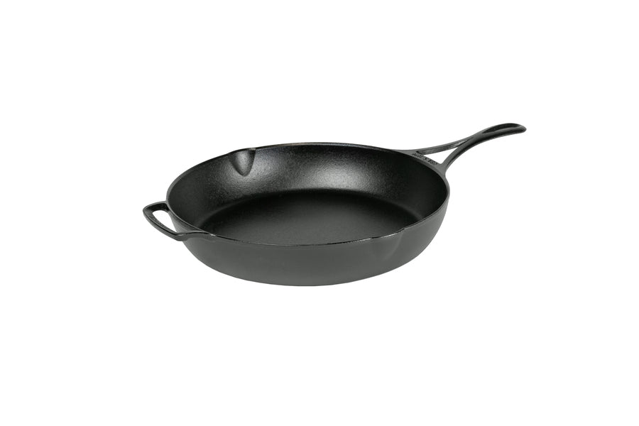 A black, cast iron skillet with a long handle and a loop handle on other side, along with two pour spouts on opposite sides.