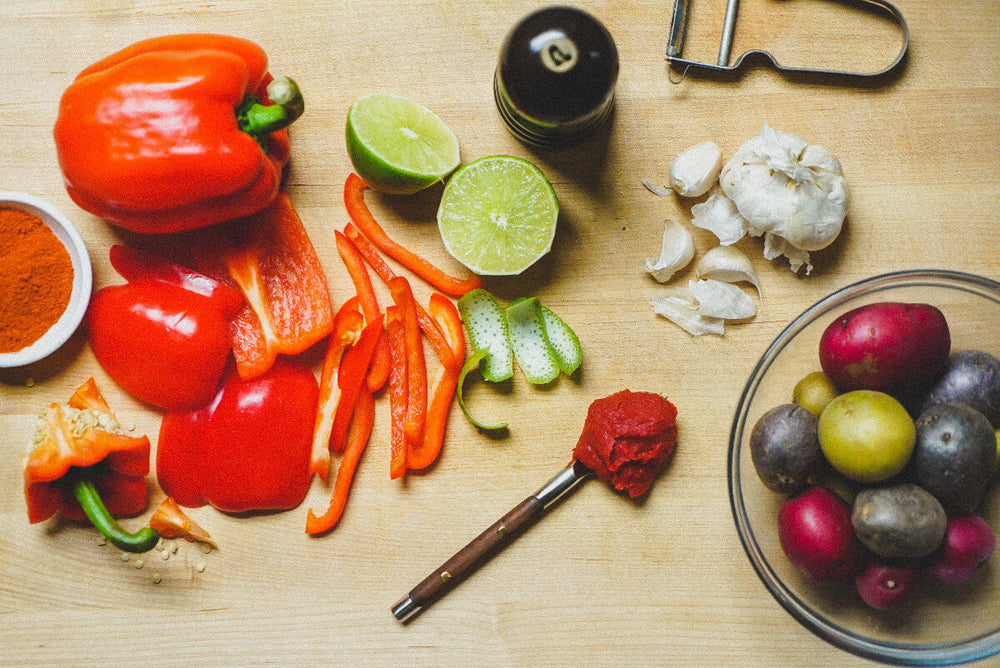 Peppers, limes, spices, and potatoes on table