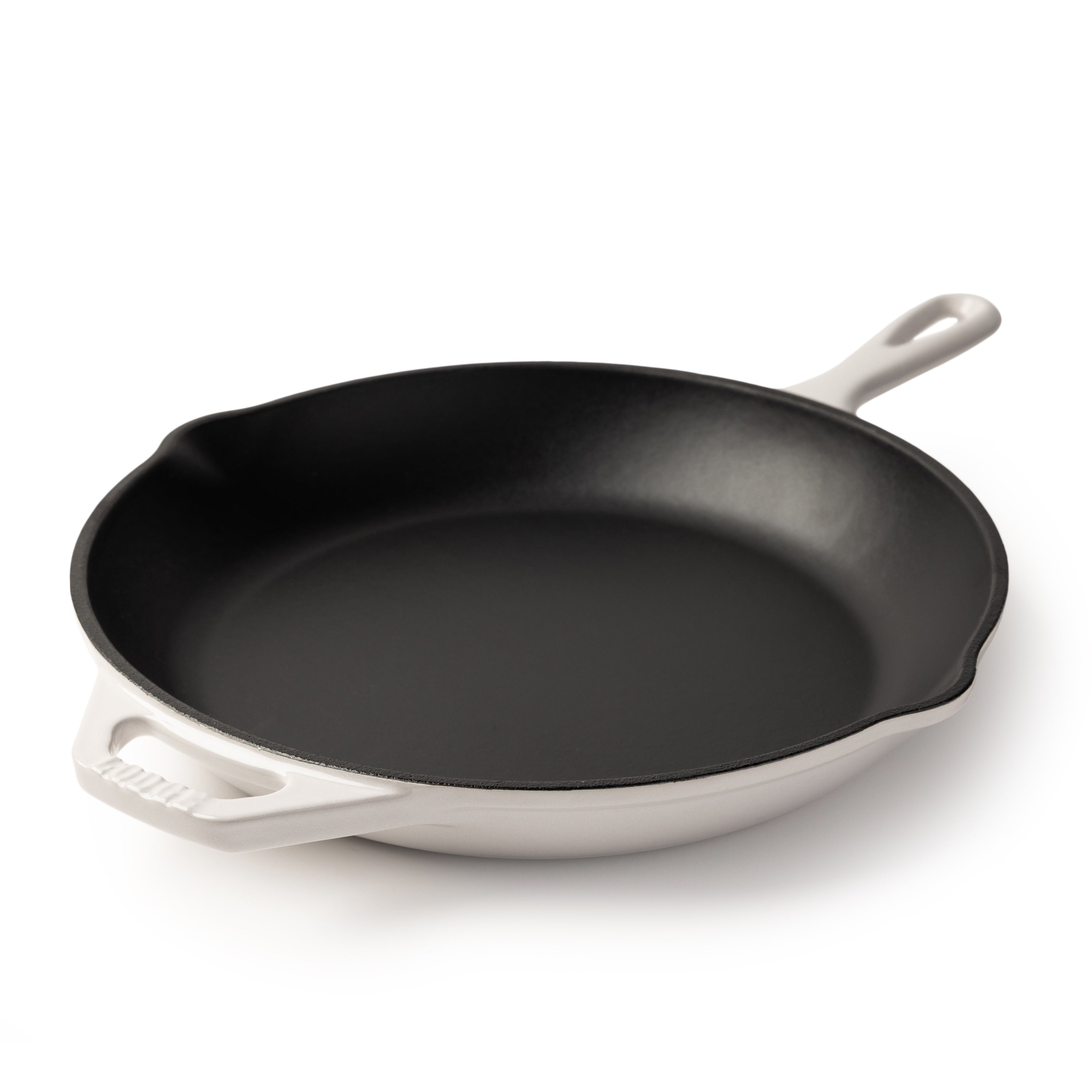 An enameled cast iron skillet with a black interior and a white exterior, featuring a single loop handle on the right and a side handle on the left, photographed on a clean white background.