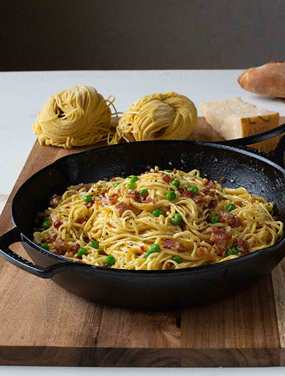 Fresh pasta Bolognese served in skillet on counter.