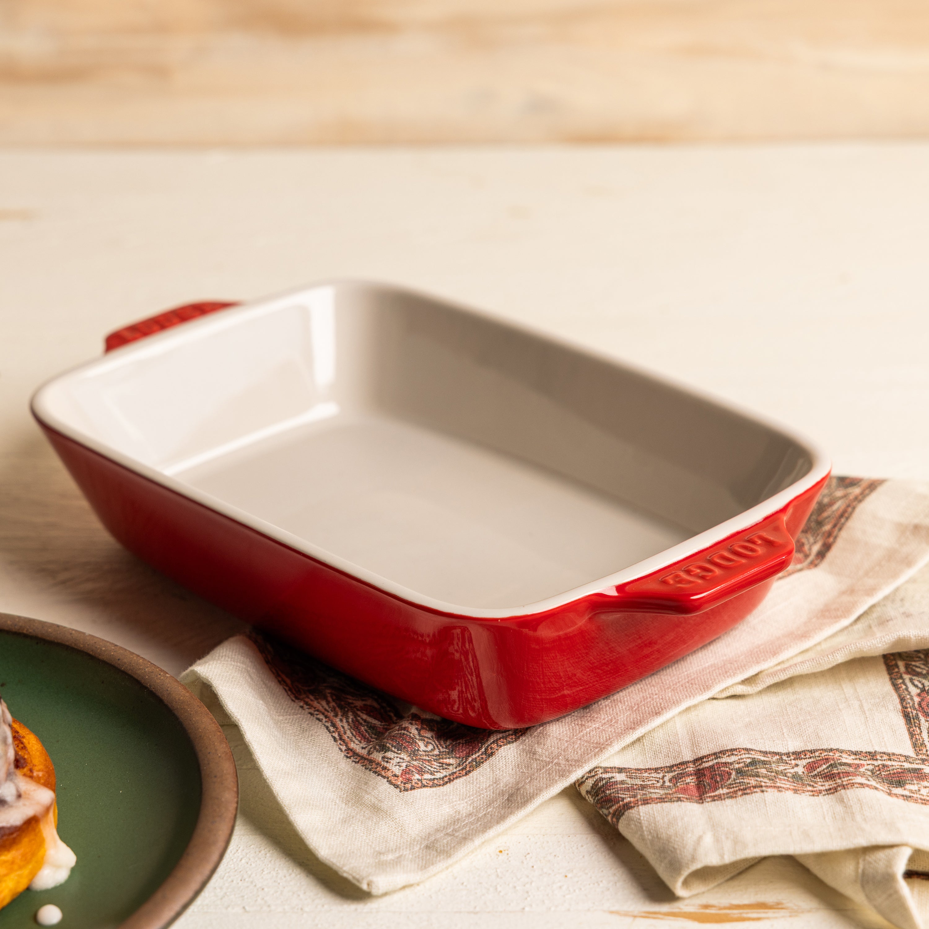 Cherry red ceramic baking dish on a counter.