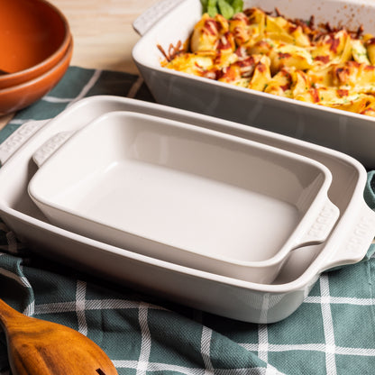 Set of ceramic baking dishes alongside a dish of pasta.