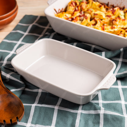 Oyster ceramic baking dish with a dish of pasta in the background.