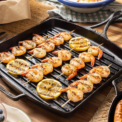 Freshly prepared shrimp skewers in pan.