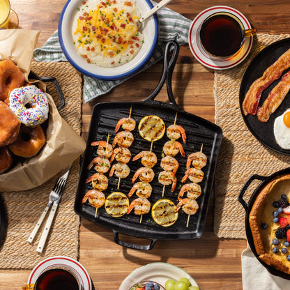 Citrus shrimp skewers served on kitchen table with pan.
