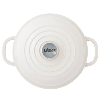 Top-down view of a white Lodge bread oven with side handles and a circular silver logo plate in the center, set against a plain white background.