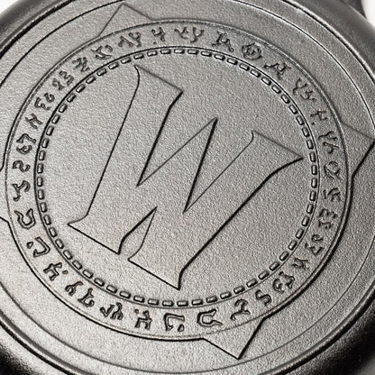 Close-up of World of Warcraft logo on the bottom of a cast iron skillet.