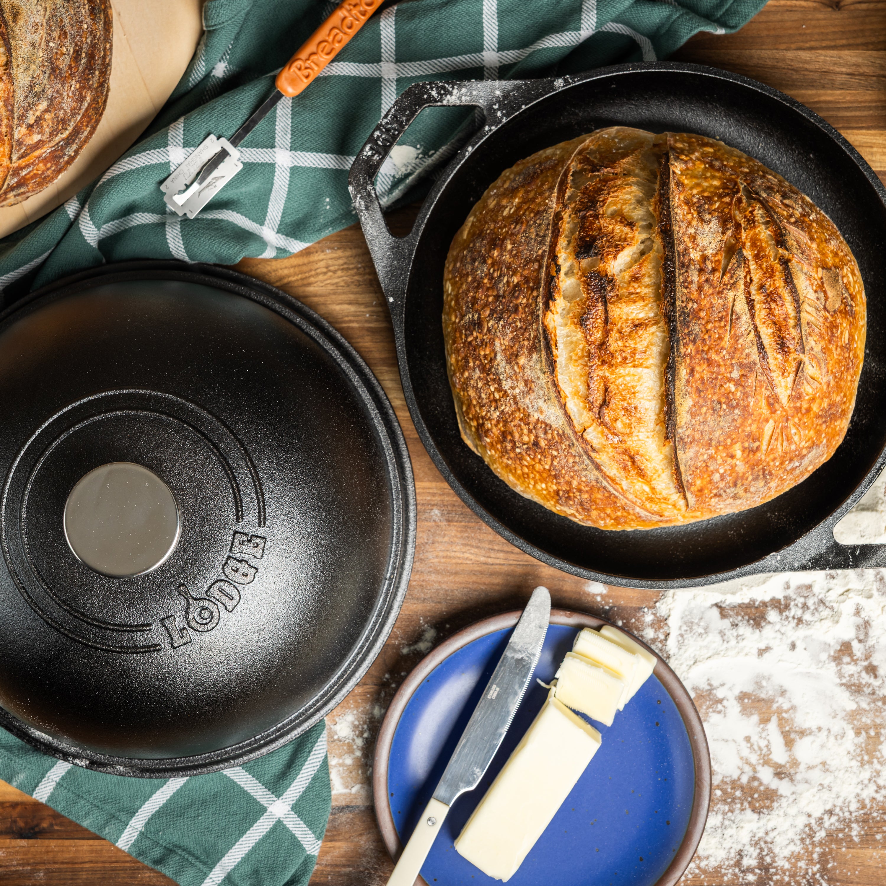Top view of baked bread and the top of bread oven on kitchen table with flour and butter.