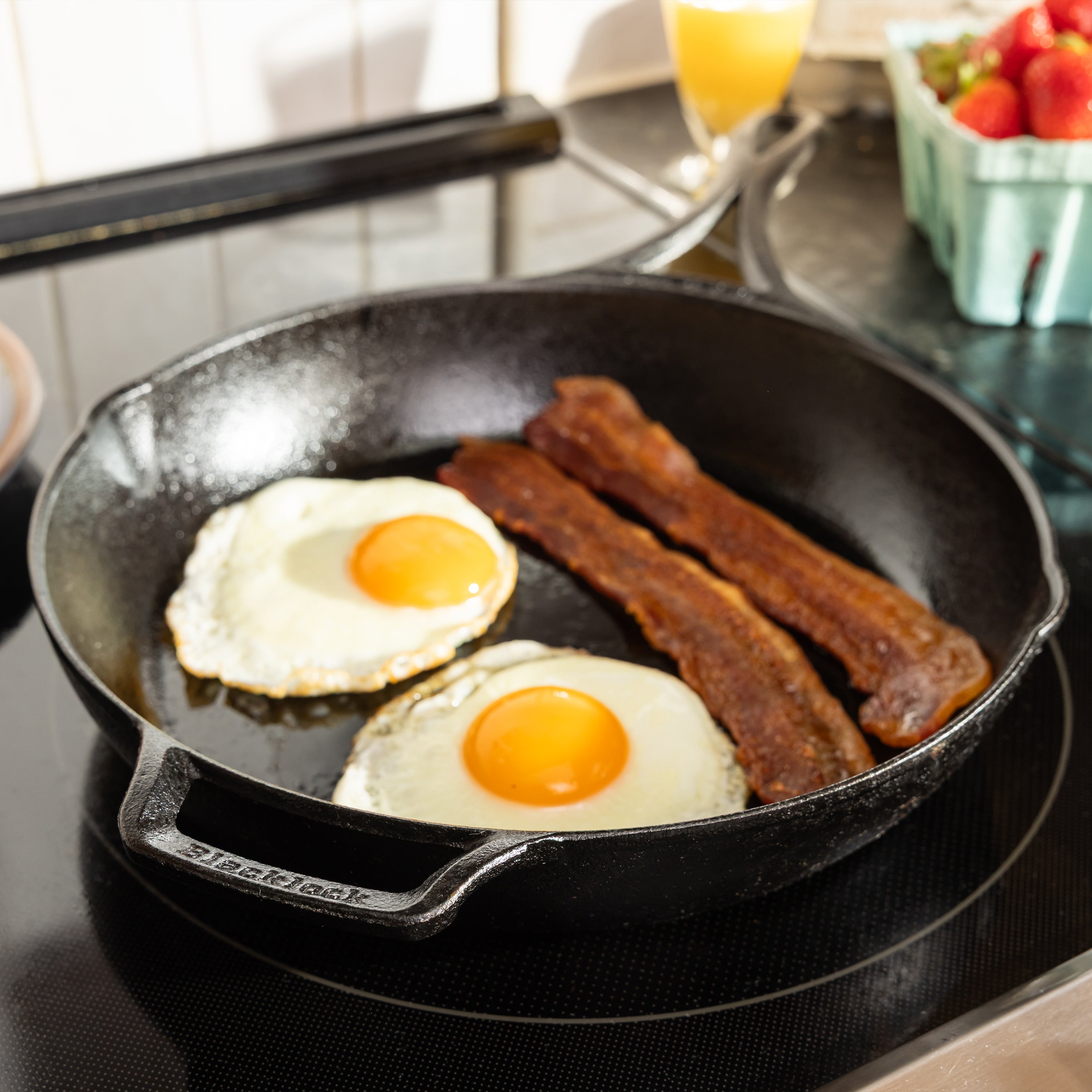 Someone cooking eggs and bacon in skillet on stove.