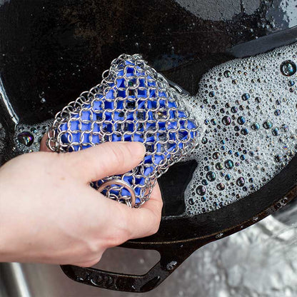 Scrubber being used to wash cast iron skillet.