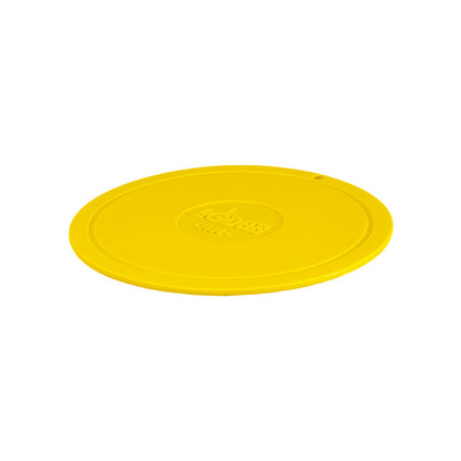 Yellow circular trivet with Lodge branding in center.