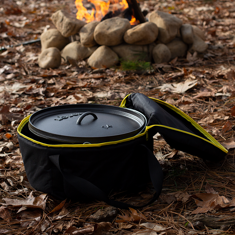 Camp dutch oven inside tote bag with top open at campsite.