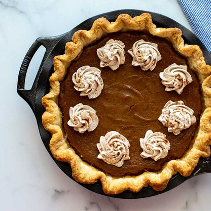 Dessert pie with whipped cream spirals and cinnamon.