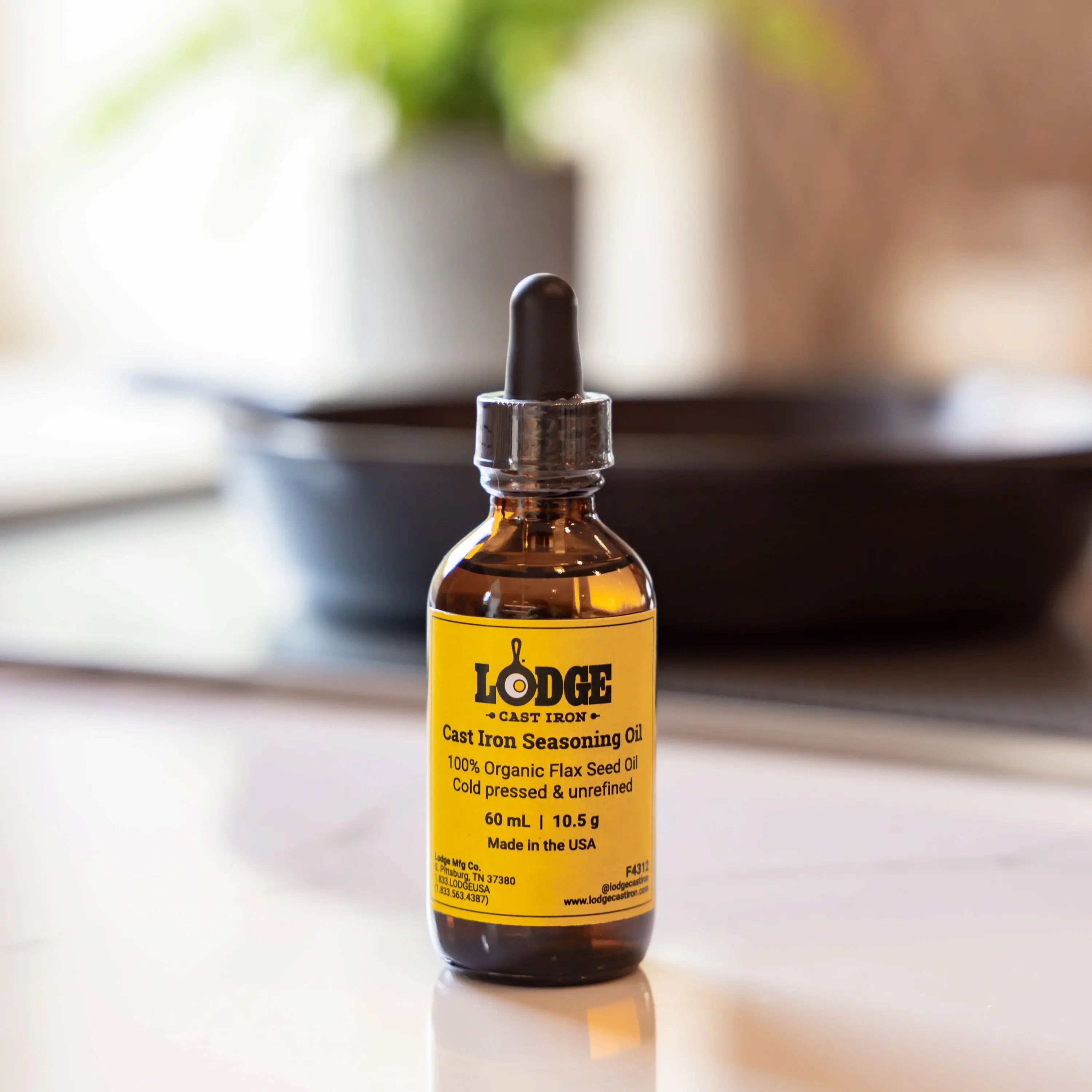 Bottle of Lodge Cast Iron Seasoning Oil on a kitchen counter with blurred background