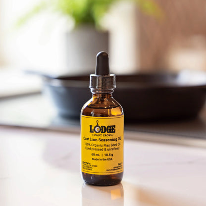 Bottle of Lodge Cast Iron Seasoning Oil on a kitchen counter with blurred background