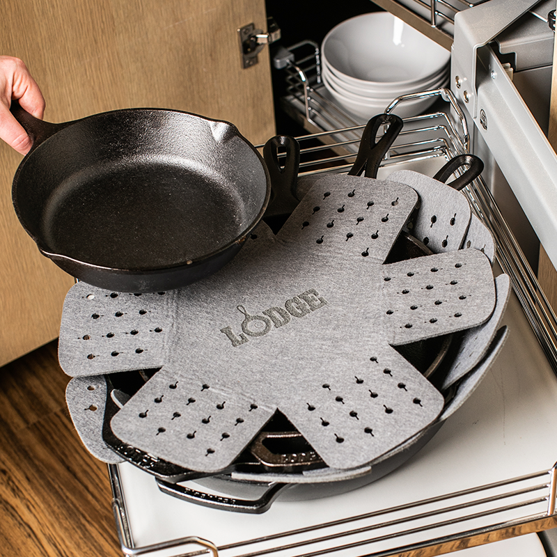 4 skillets stacked on top of each other with a protector in between each one.