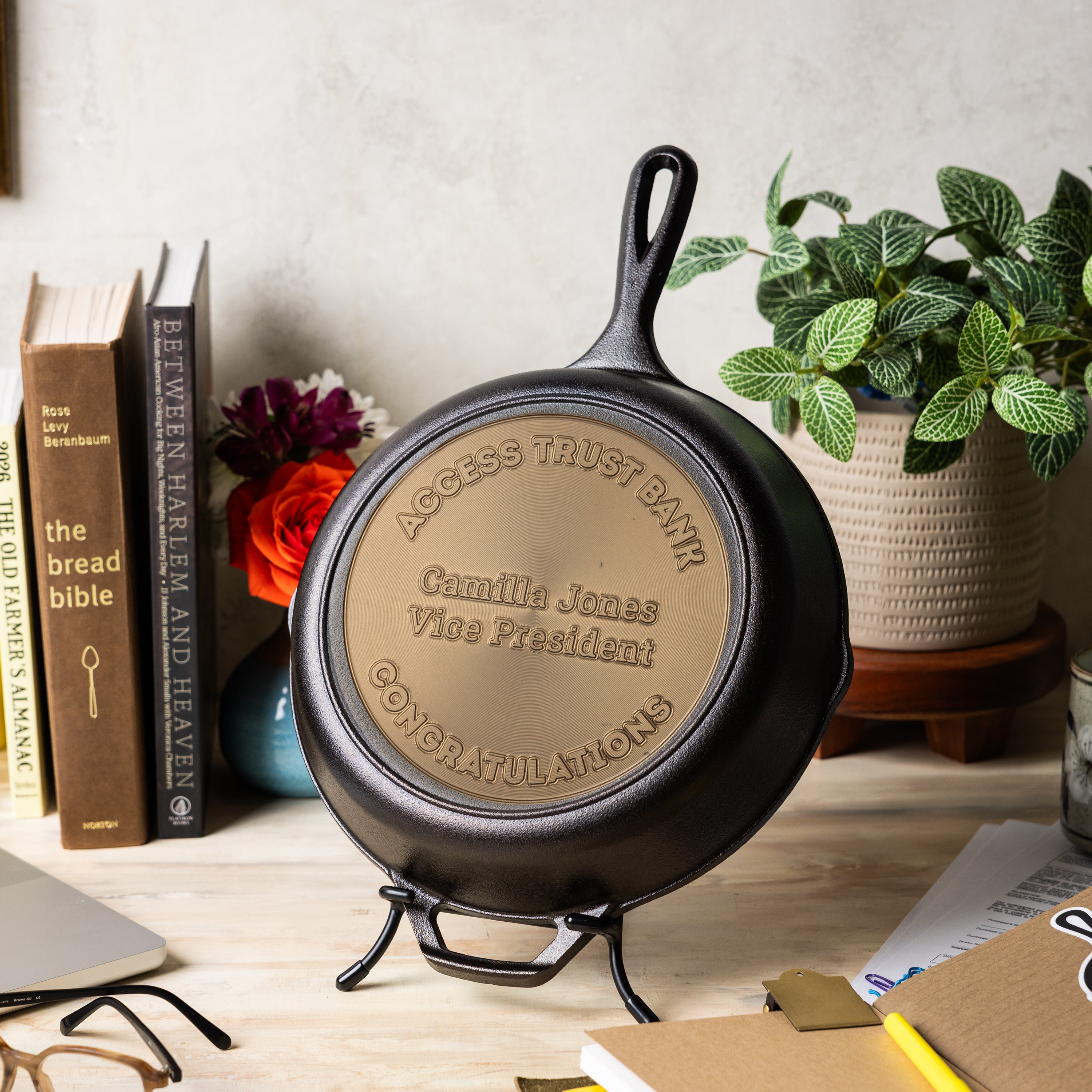 Engraved skillet displayed on a table with personalized congratulatory text for the recipient.