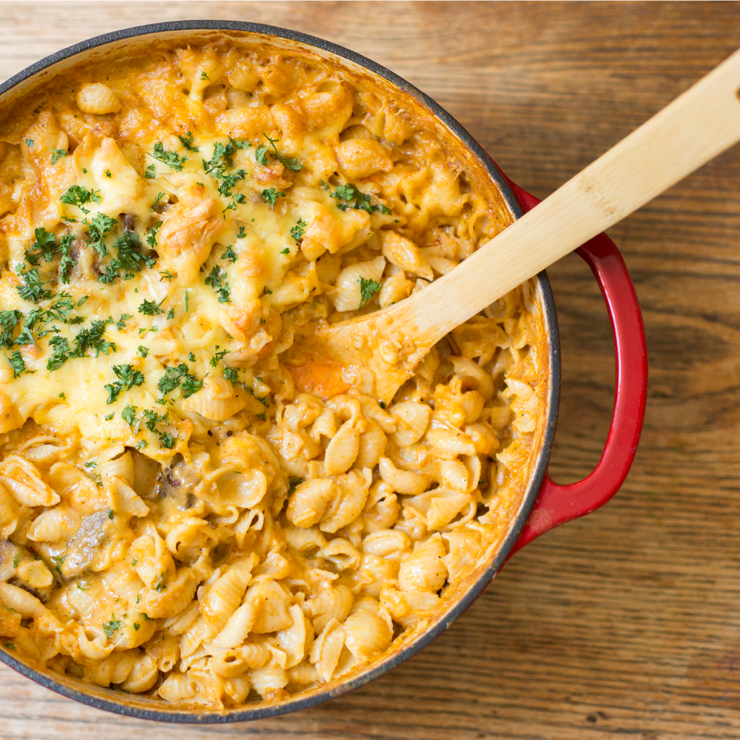 Fresh macaroni and cheese being served from dutch oven.