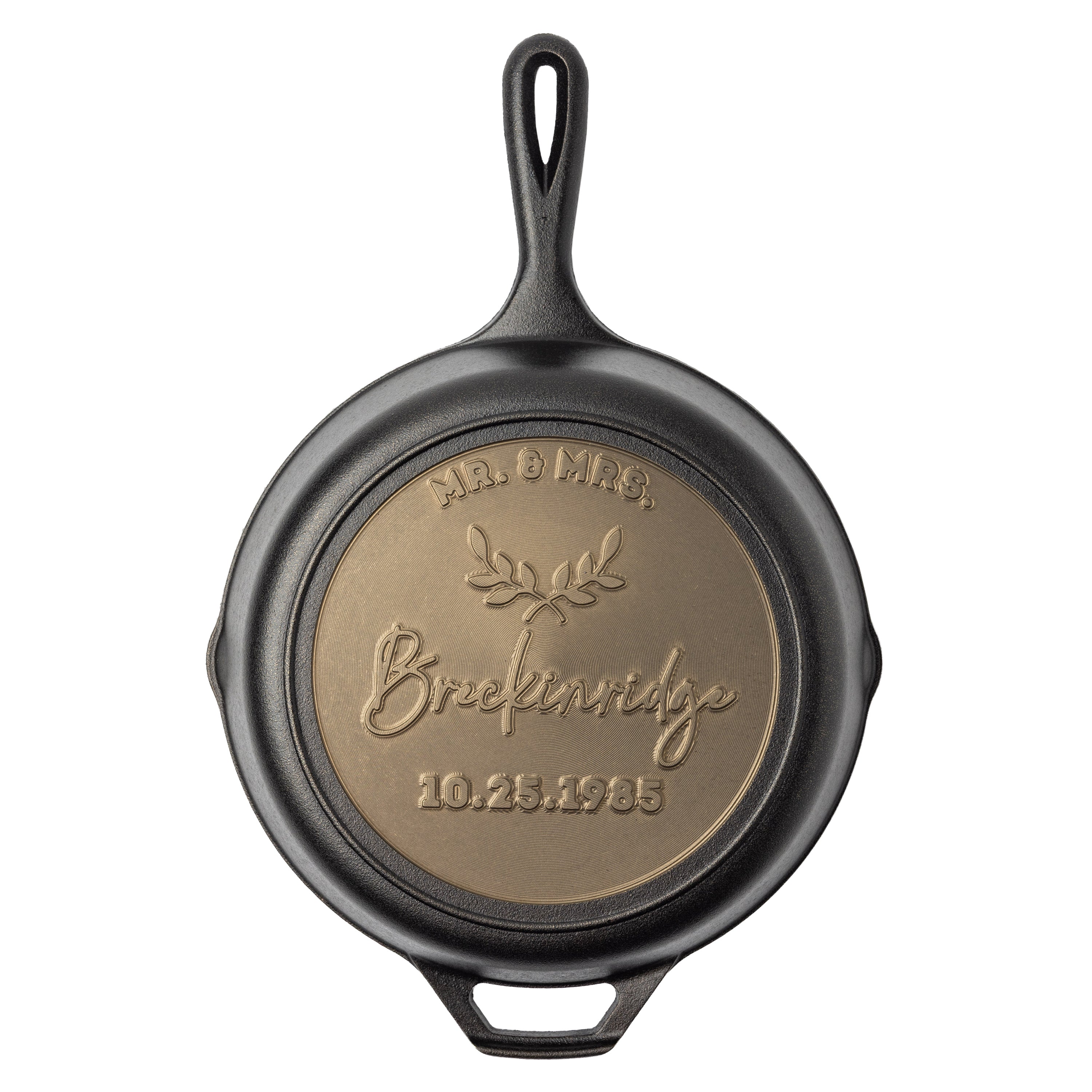 Bronze, personalized engraving on back of skillet with 3 editable text fields, one on the top arc, one in the center, and one below. In between the top arc and middle text there's a decorative laurel leaf icon.