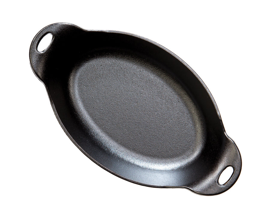 Top view of A black cast iron oval server with two handles.