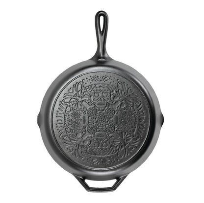 A black cast iron skillet with a butterfly sugar skull design on bottom of skillet.