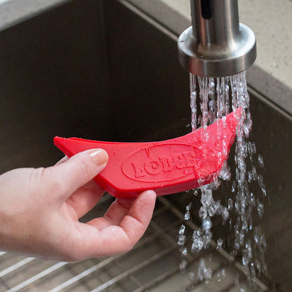 Silicone assist handle being rinsed off in sink.