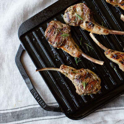 Herb-marinated lamb chops freshly prepared and presented on grill pan.