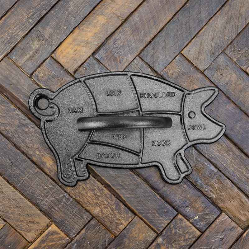 Cast iron pig-shaped press on a wooden surface