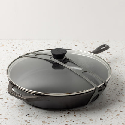 Gray lid latch being use with a glass lid and classic skillet.