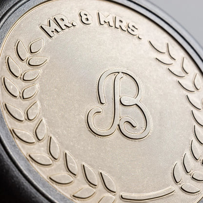 Close-up of bronze engraving on back of skillet, middle initial in cursive font.