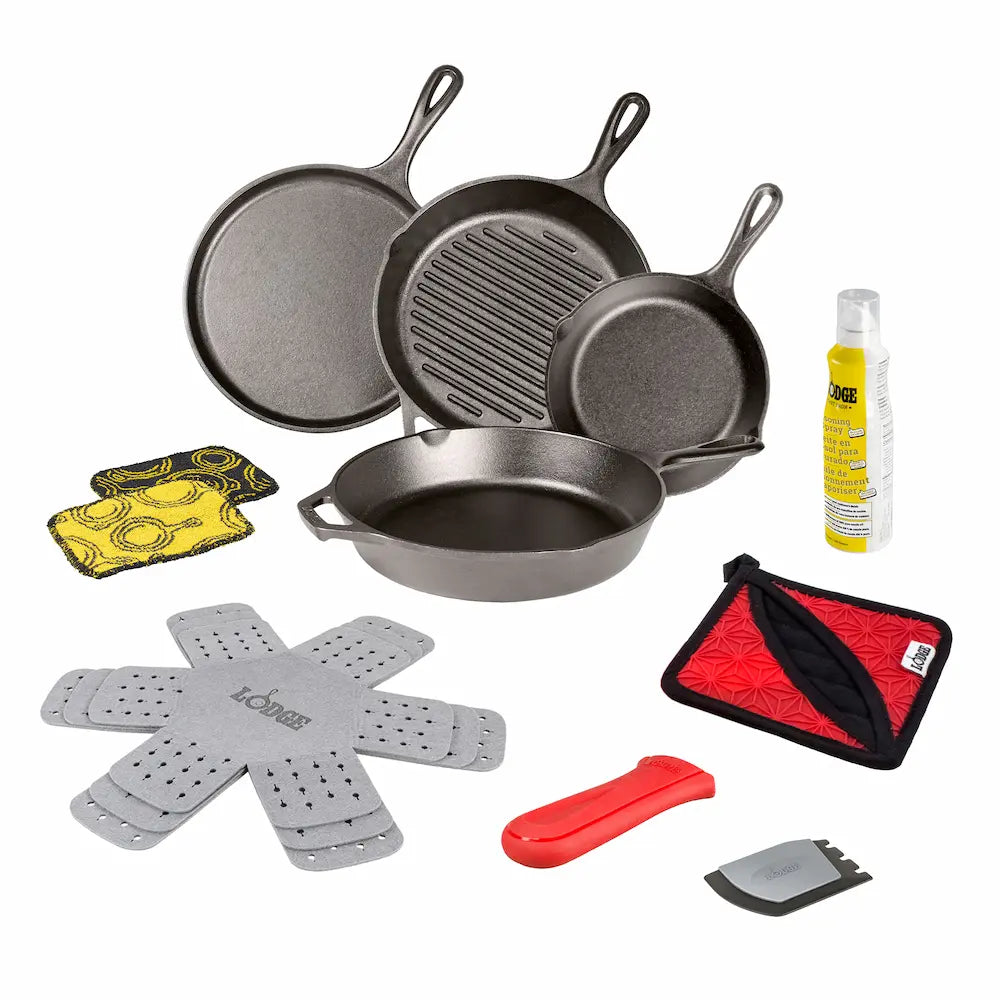 Set of cast iron cookware and accessories on a white background