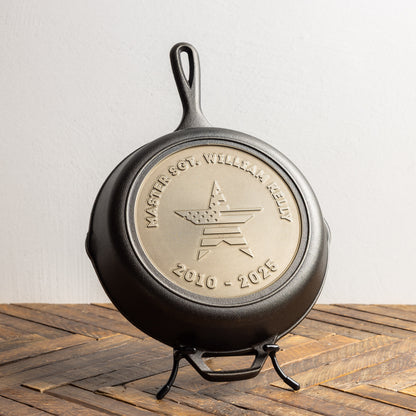 Cast iron skillet with engraved logo and text on a wooden surface