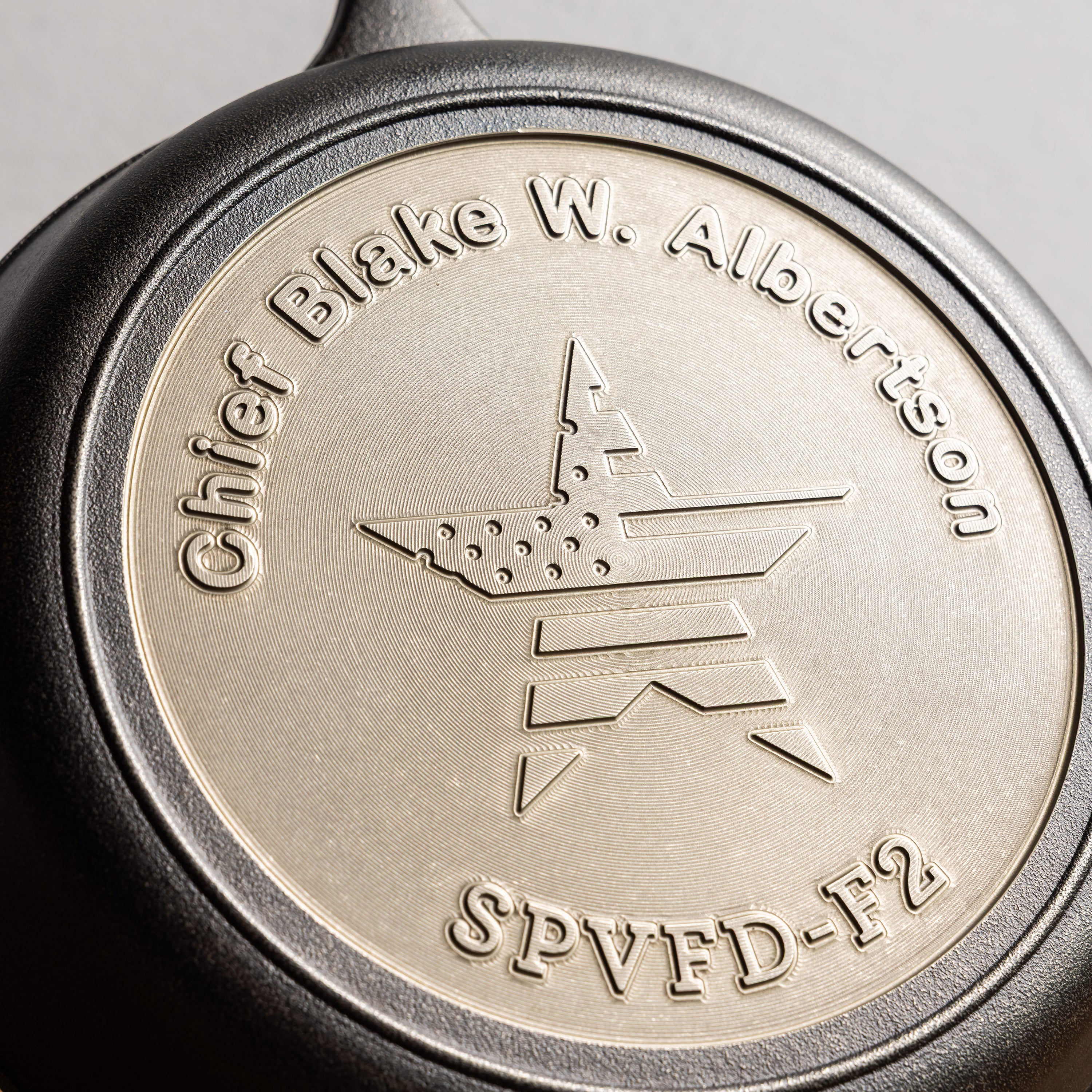 Close-up of a metallic engraving with text and design.