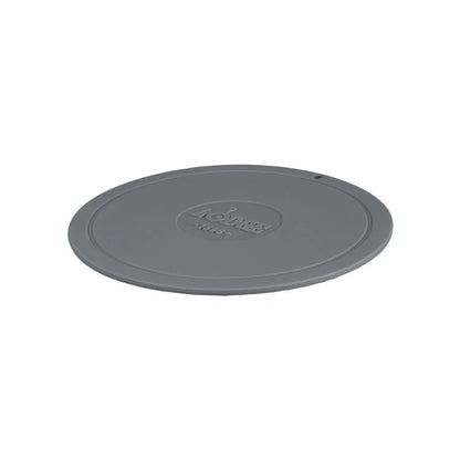 Grey circular trivet with Lodge branding in center.