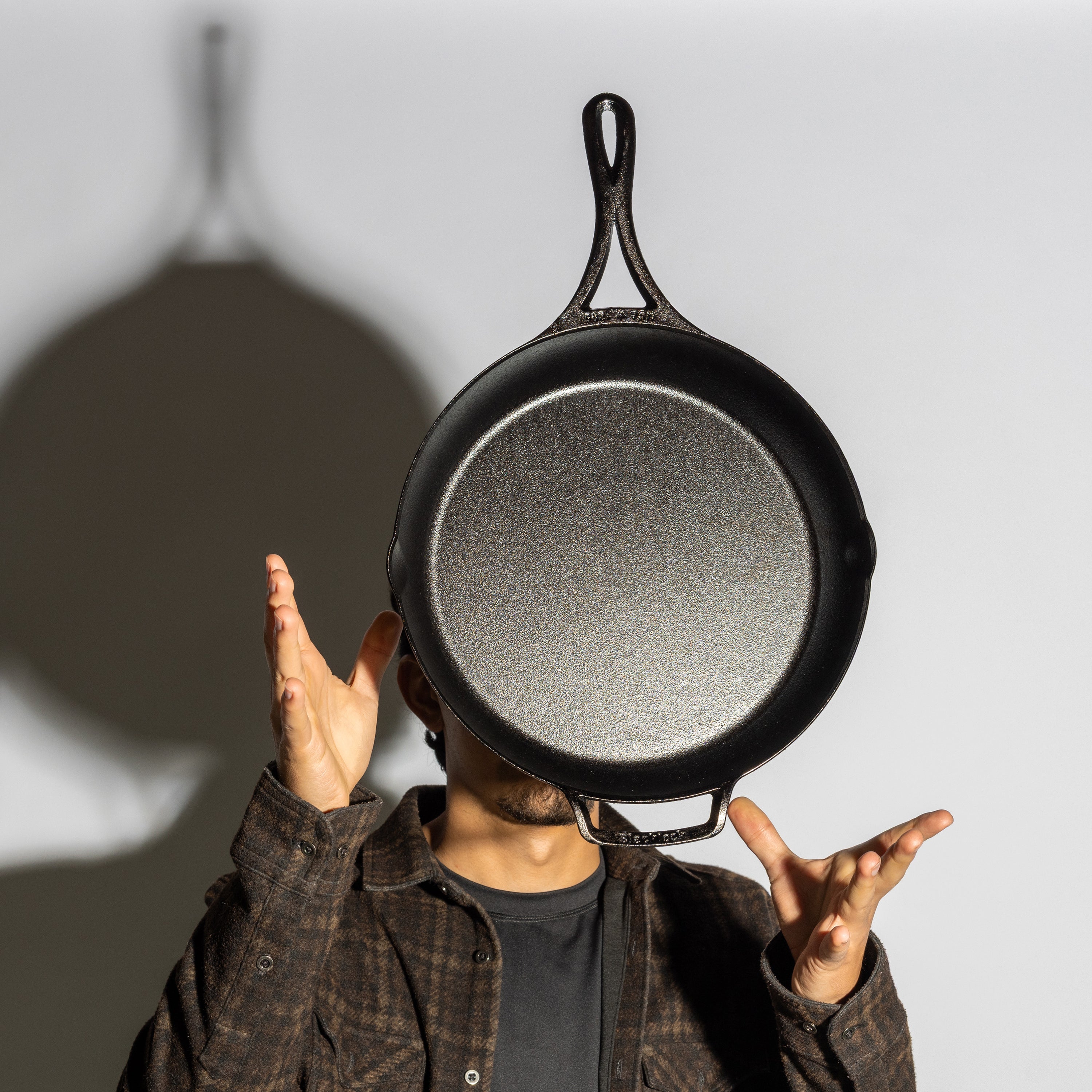 Someone tossing skillet in air showing cooking surface and how it's lightweight.