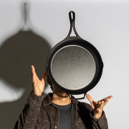 Someone tossing skillet in air showing cooking surface and how it's lightweight.
