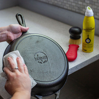 Someone rubbing in the seasoning spray oil on their clean cast iron skillet.