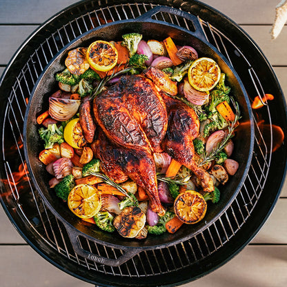 Chicken being cooked with veggies in pan.