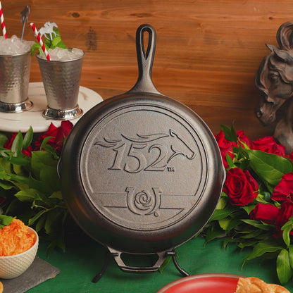 Two people cheers with mint julep's in front of Kentucky Derby Skillet,