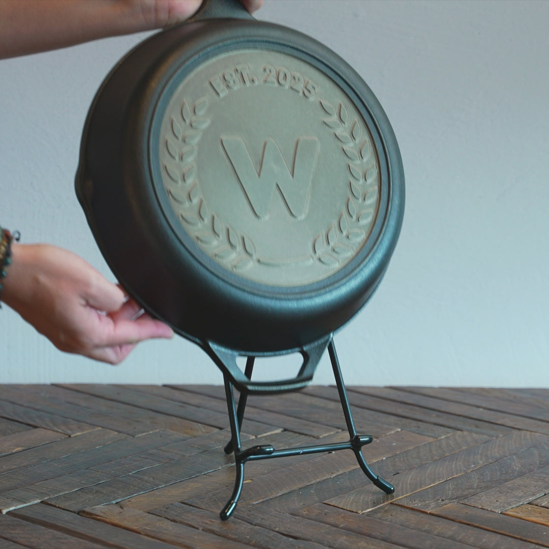 Someone placing skillet onto display stand.
