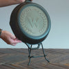 Someone placing skillet onto display stand.