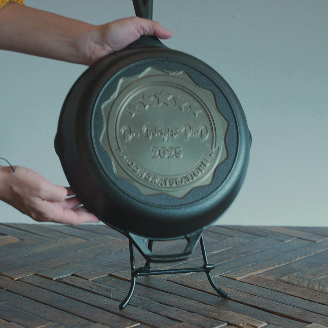Personalized congratulations skillet being placed on display stand.
